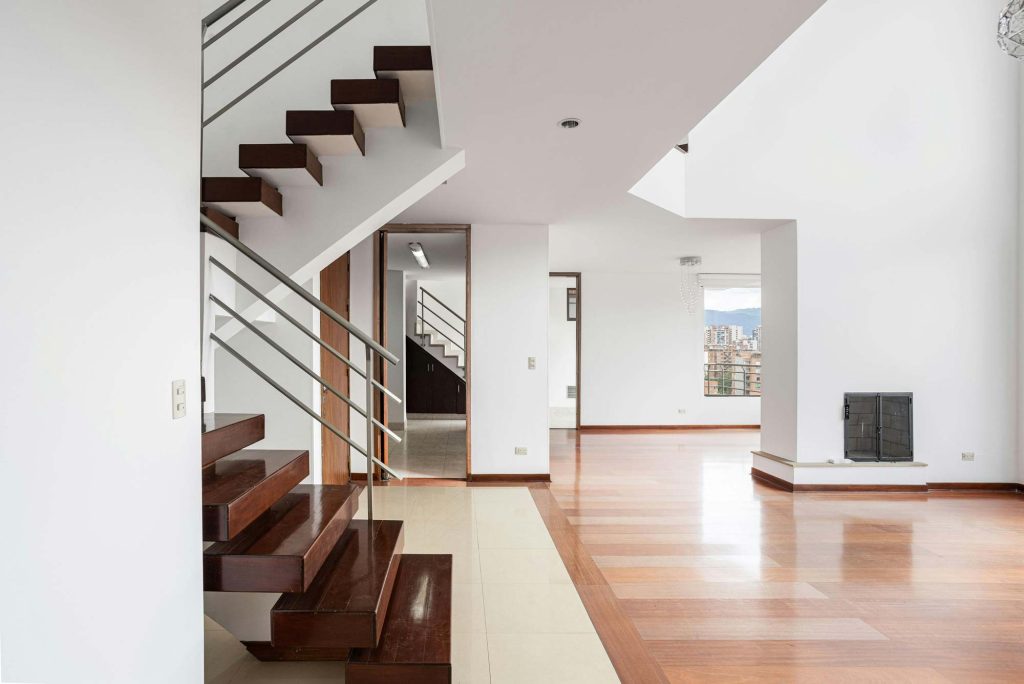 Světlý moderní interiér s dřevěným schodištěm a otevřeným obytným prostorem